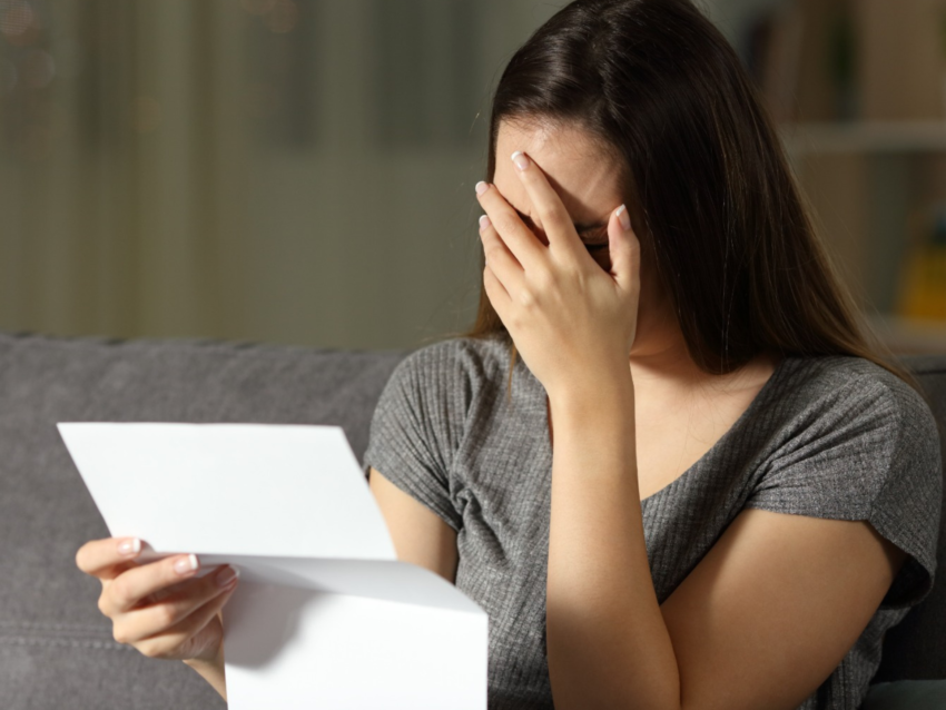 Frustrated homeowner reading denied roof insurance claim letter — All Site Builders helps CT homeowners avoid delays and denials.